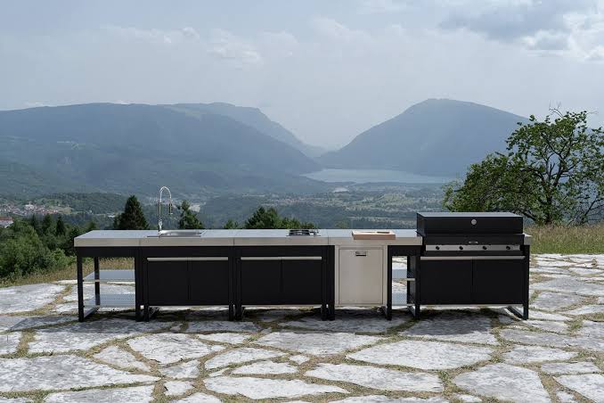 Cuisine extérieure modulaire avec plan de travail métallique et barbecue face au paysage
