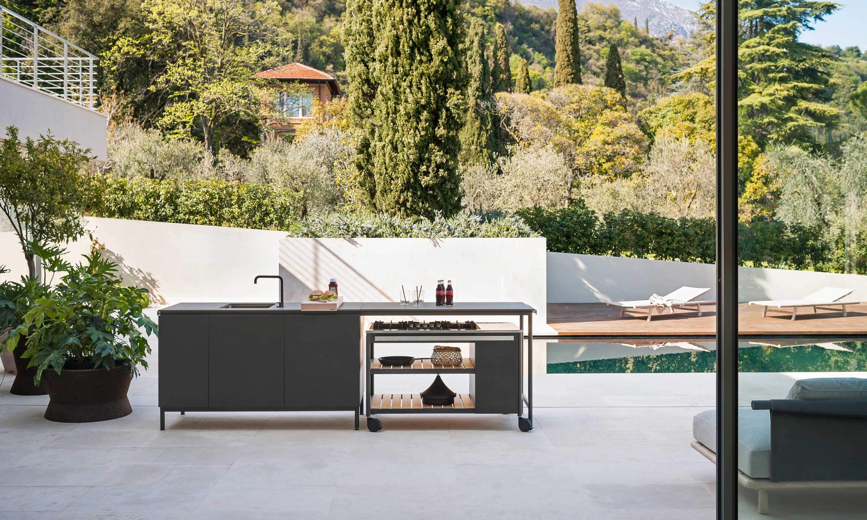 Îlot de cuisine extérieure sombre avec évier et module mobile sur terrasse