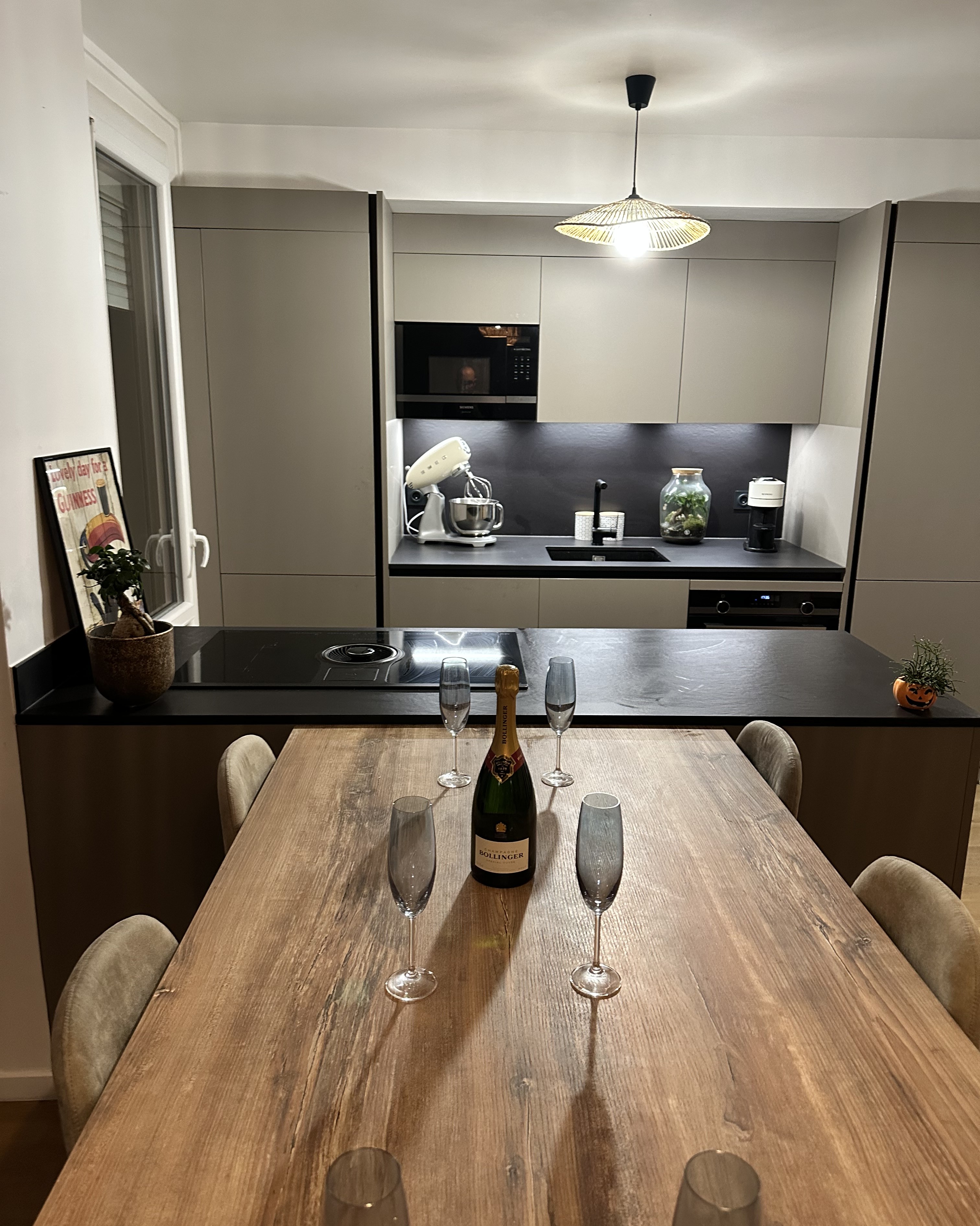 Cuisine familiale sur mesure, plan de travail en pierre et façades bois chaleureuses